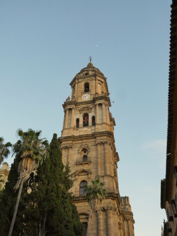 The North Tower as seen from the streets below. It's a tower in Renaissance style, 84m high and built in a slightly yellow stone which contrasts against the blue sky.