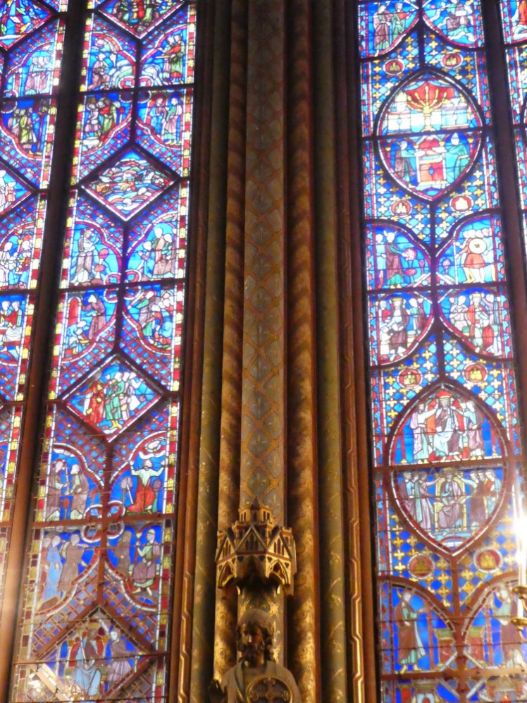 A thick Gothic pillar disguised as multiple thin pillars and each painted in different gaudy colours and patterns at Paris's Sainte-Chapelle