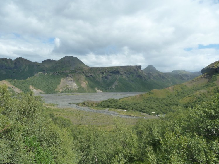 Views over Þórsmörk's grey riverbanks and green mountains from halfway up our hike.