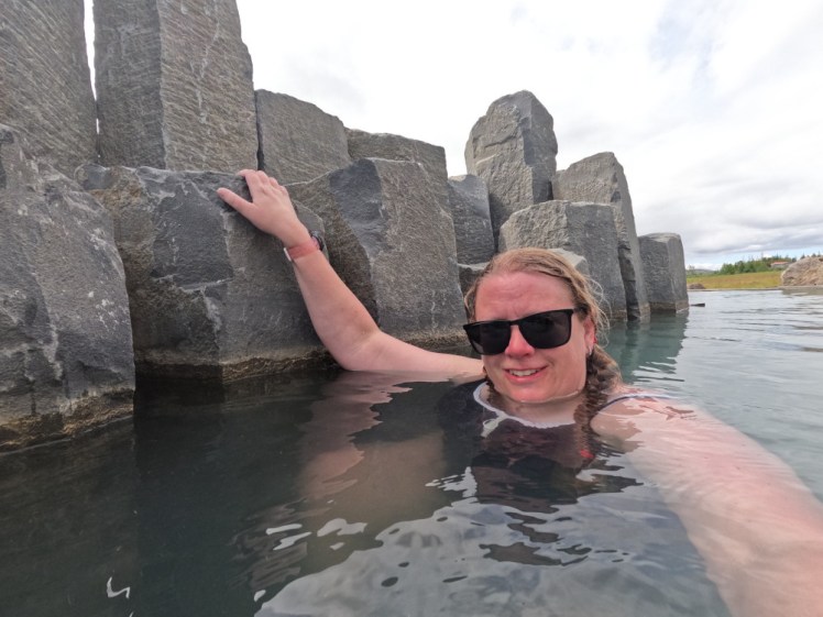 Me, looking quite pink, in the basalt canyon, hanging onto the columns with one hand as if I'm trying to climb them. Behind me is the quiet zone.