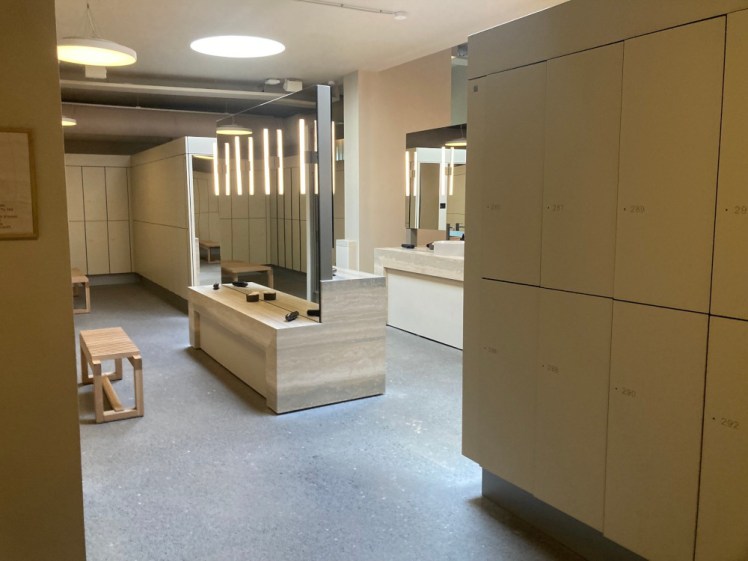 The changing rooms at Laugaras, featuring pale wood-fronted lockers and vanity units with massive mirrors for beautifying afterwards.
