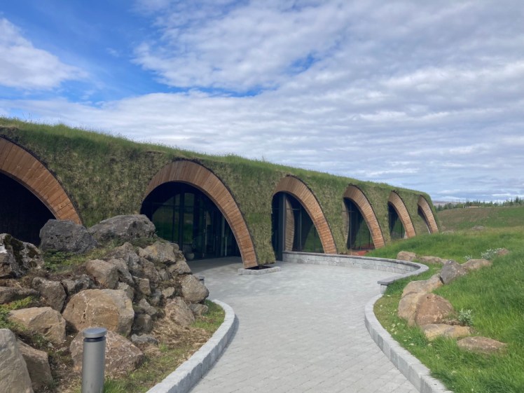 The entrance to Laugaras Lagoon, a single-storey building with arches along the front, entirely covered in turf and greenery.