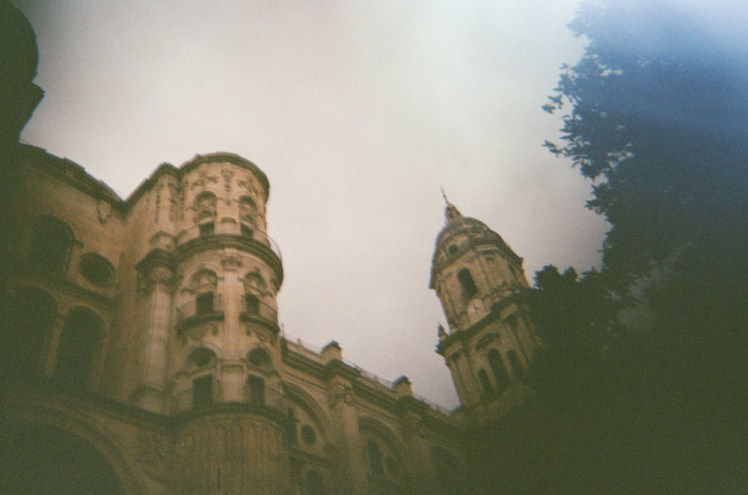 Malaga cathedral from the west end. There's a lot of light leaking onto the trees on the right hand side.