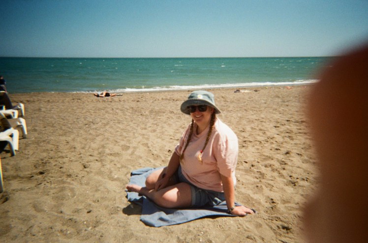 Me sitting on a towel on the beach. In traditional 90s style, there's a bit of thumb blocking off the right hand side.