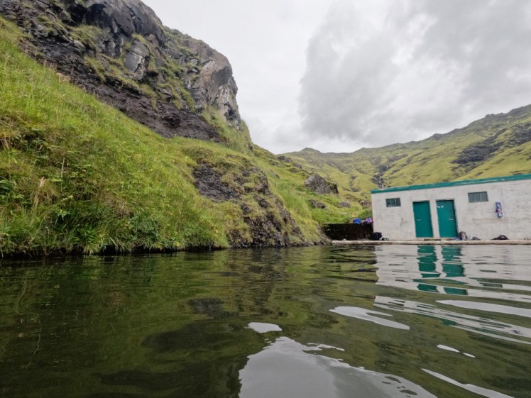 Seljalandsfoss, a concrete pool with the mountain forming one of its sides.