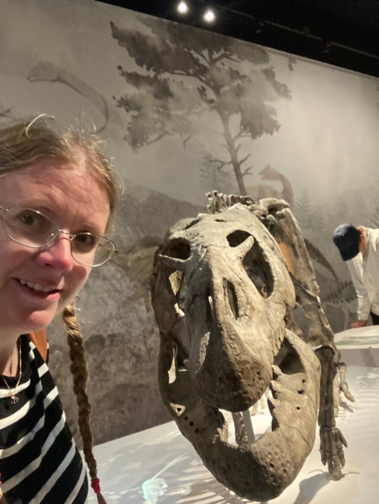 A selfie with a dinosaur skeleton - probably a fake one, inside the Experience Centre exhibit.