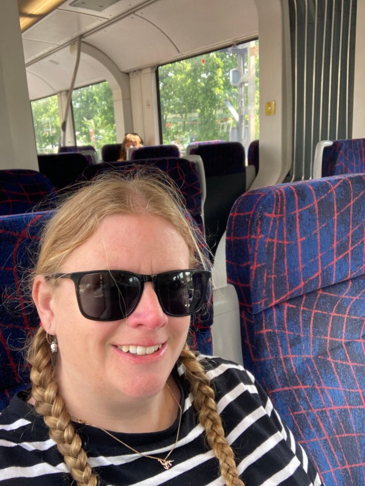 Me, in a black and white striped top and sunglasses, on the train on the way to Rødvig.